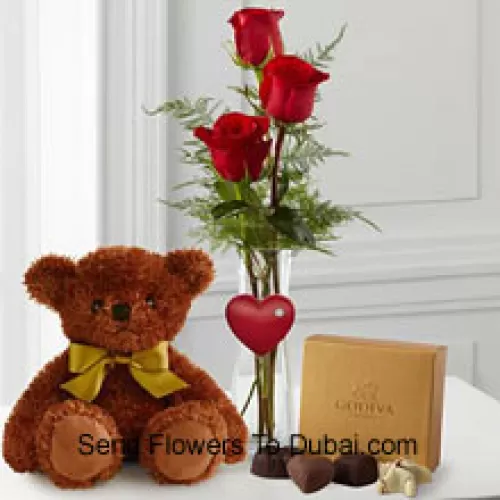 <b>Product Description</b><br><br>Three Red Roses With Some Ferns In A Vase, A Cute Brown 10 Inches Teddy Bear And A Box Of Godiva Chocolates. (We reserve the right to substitute the Godiva chocolates with chocolates of equal value in case of non-availability of the same. Limited Stock)<br><br><b>Delivery Information</b><br><br>* The design and packaging of the product can always vary and is subject to the availability of flowers and other products available at the time of delivery.<br><br>* The "Time selected is treated as a preference/request and is not a fixed time for delivery". We only guarantee delivery on a "Specified Date" and not within a specified "Time Frame".